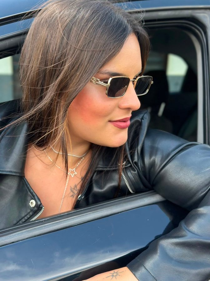 Julia Vasconcelos de óculos escuros no carro